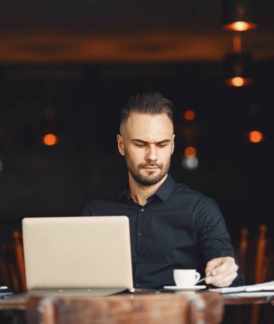 Man drinks coffe. Businessman reads documents. Director in a shirt.